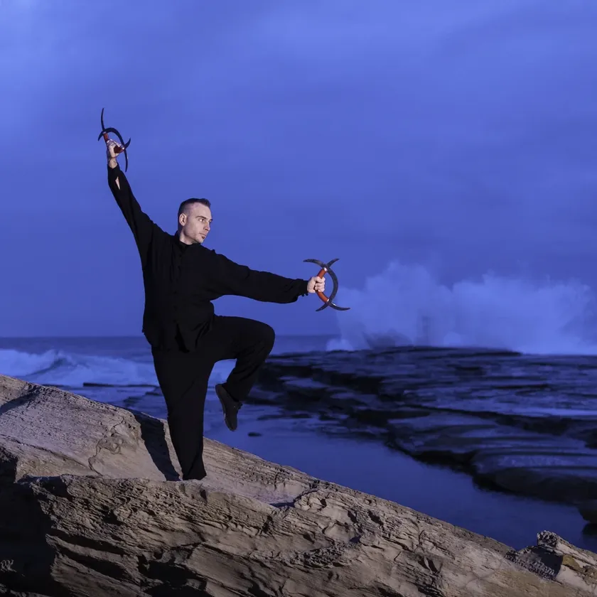 Grant Mundy training Baguazhang on coastal rocks at dusk