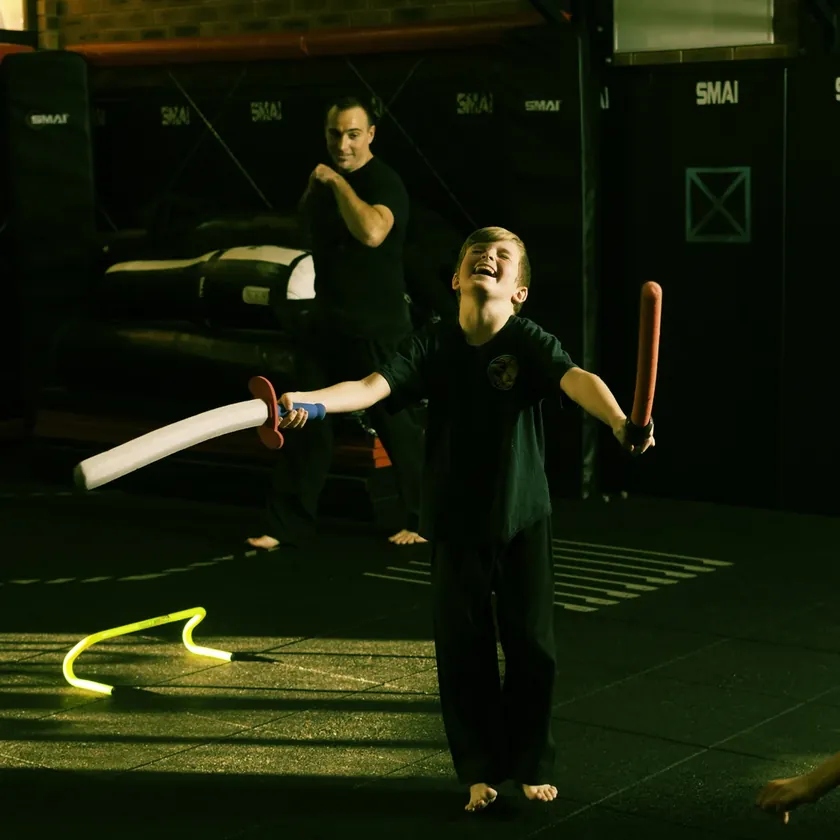 A Little Dragons student mid-swing during the blind swordsman game