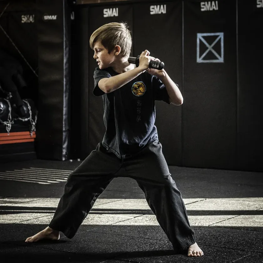 A Little Dragons student mid-swing in a sword form