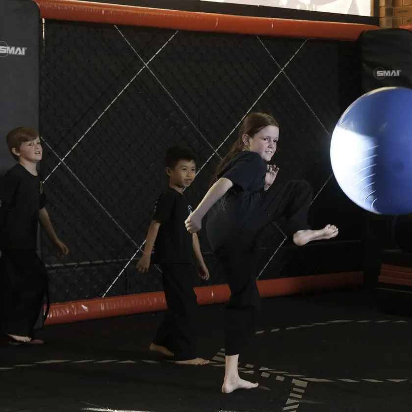 Little Dragons students playing a bounce-back reflex game with an exercise ball