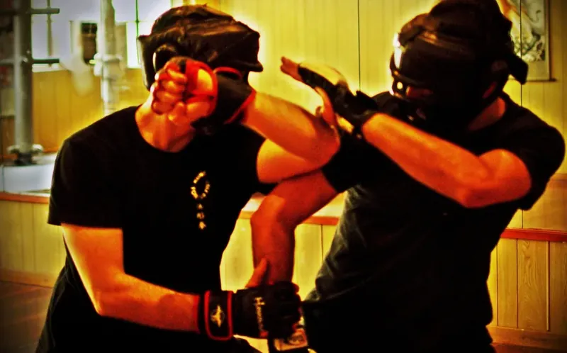 Two Wu Xing Dao students sparring with head gear in the training hall