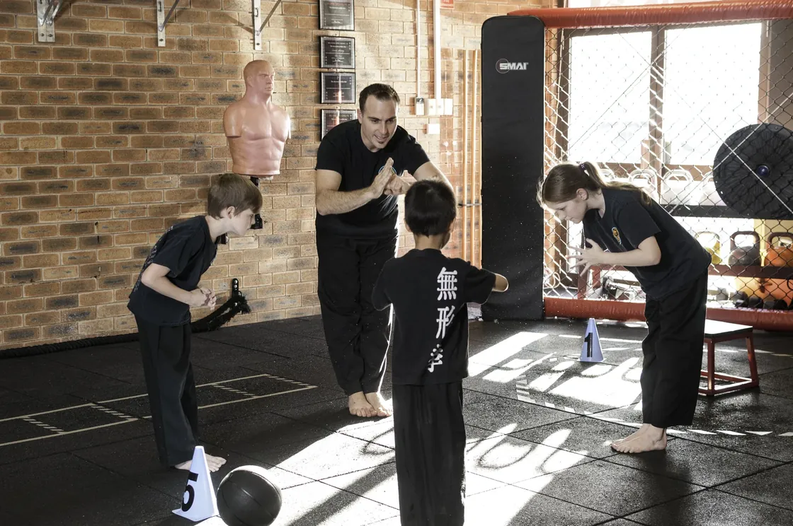 Head Instructor Grant Mundy guiding Little Dragons students through a focus drill