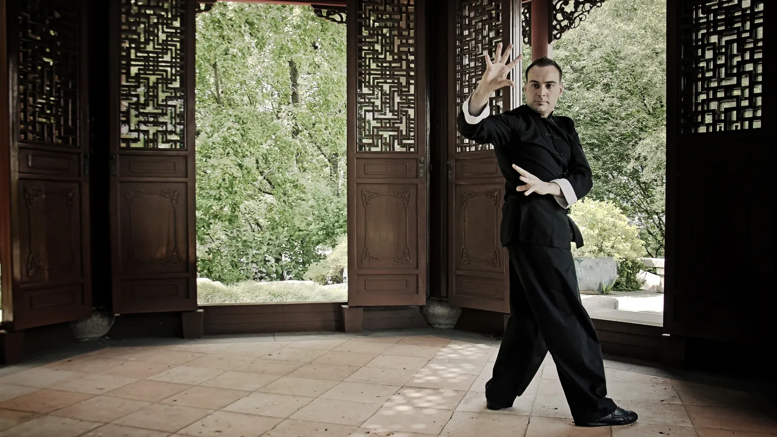 Head Instructor Grant Mundy performing a Baguazhang single changing palm in a Chinese pavilion