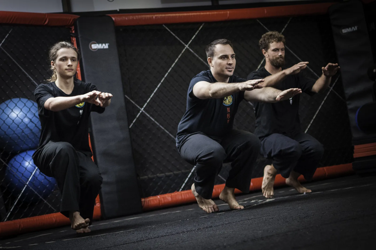 Adults of different ages train low stances together in the kung fu school.