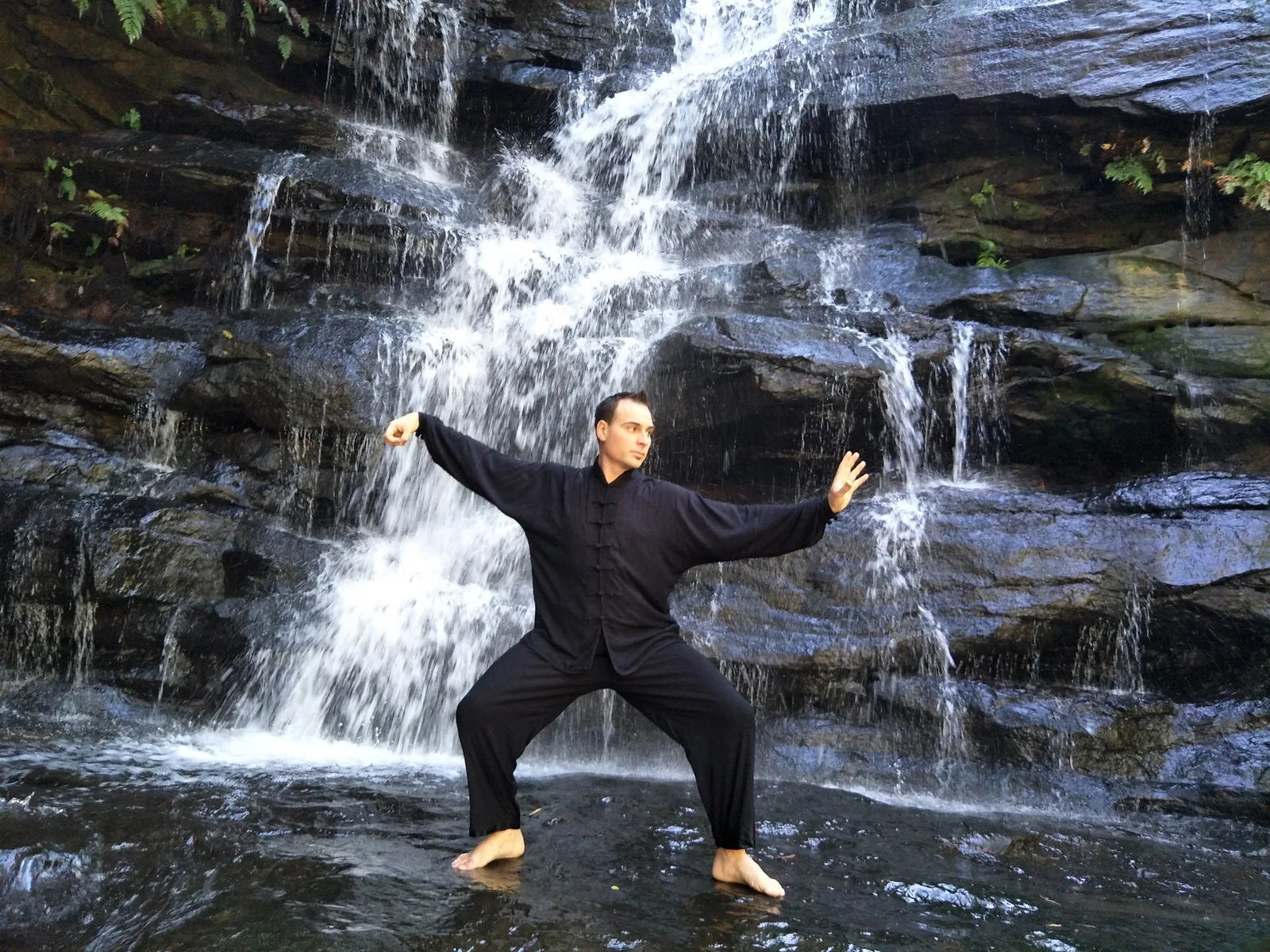 Qigong standing practice in front of a waterfall at Somersby Falls.