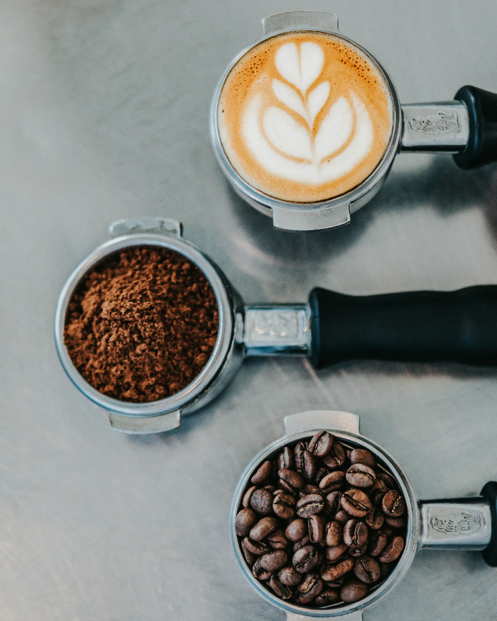 Coffee beans, ground coffee and a latte from above.