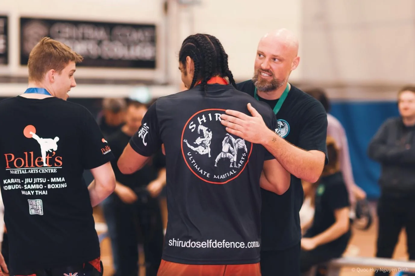Competitors congratulate other winners at a Martial Arts tournament; shirts show Pollet's Martial Arts Centre and shiriudoselfdefence.com.au.
