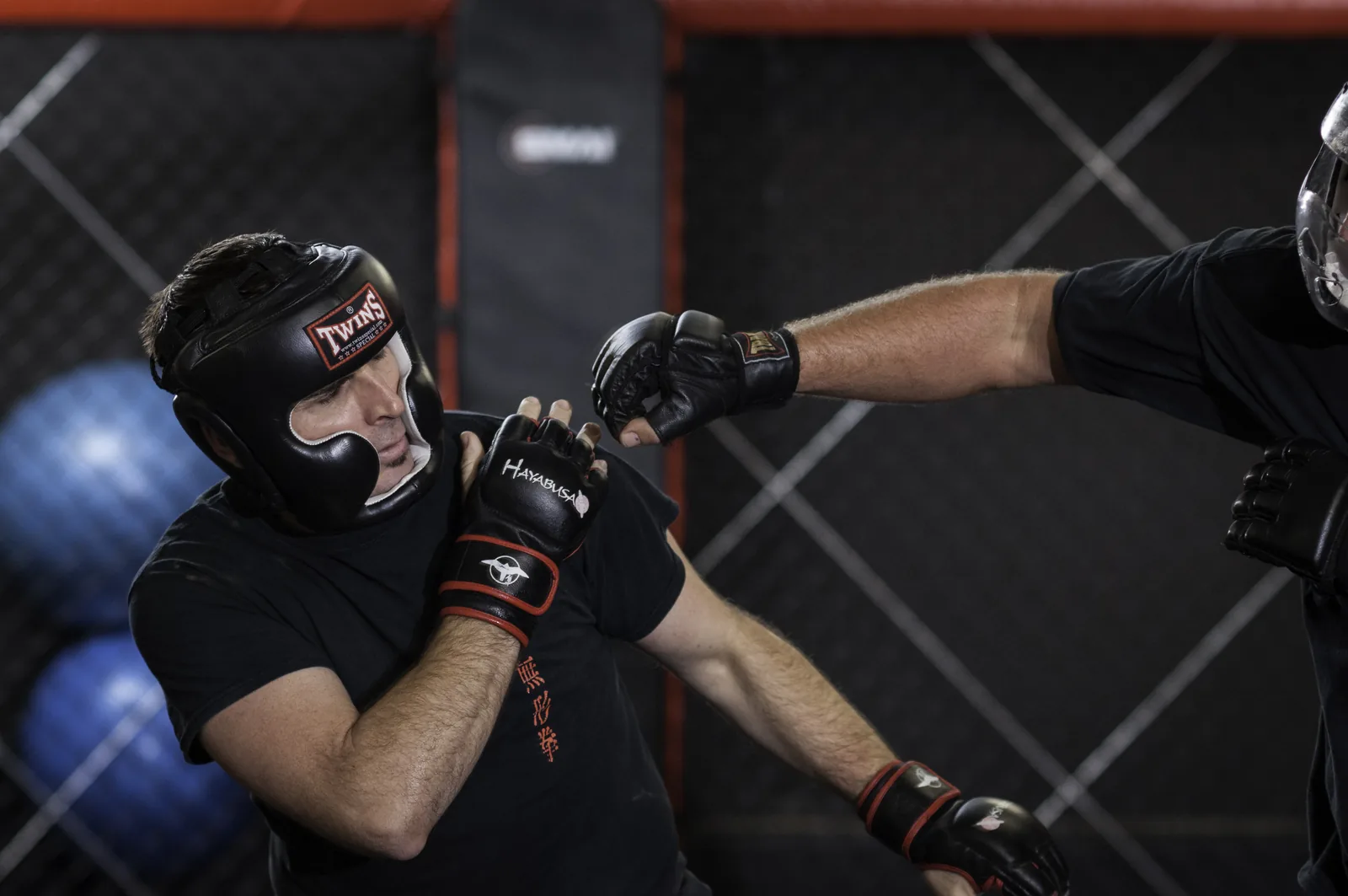 A student in headgear and gloves throws a punch during sparring.