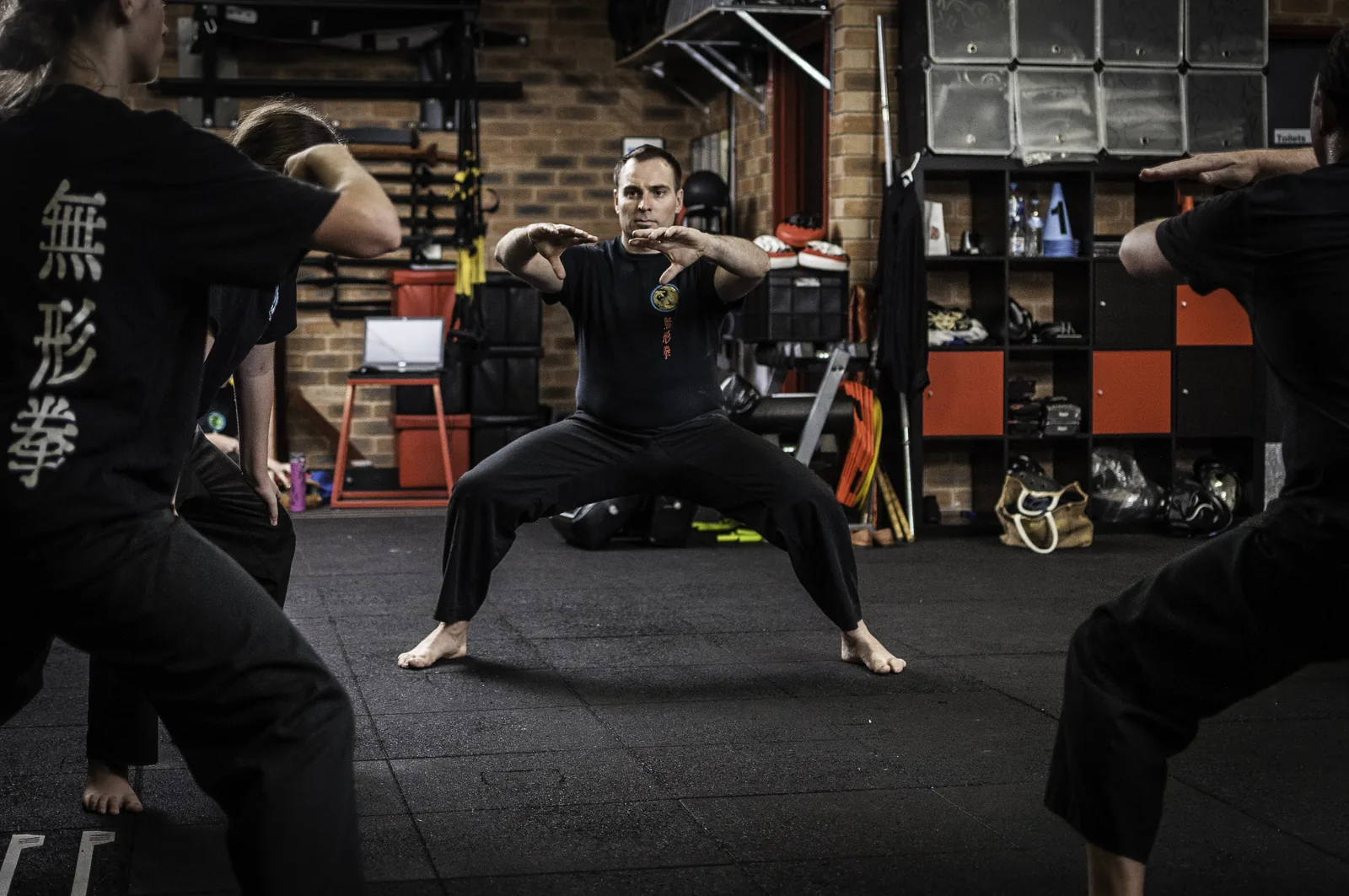 Students build leg strength holding a deep horse stance in class.