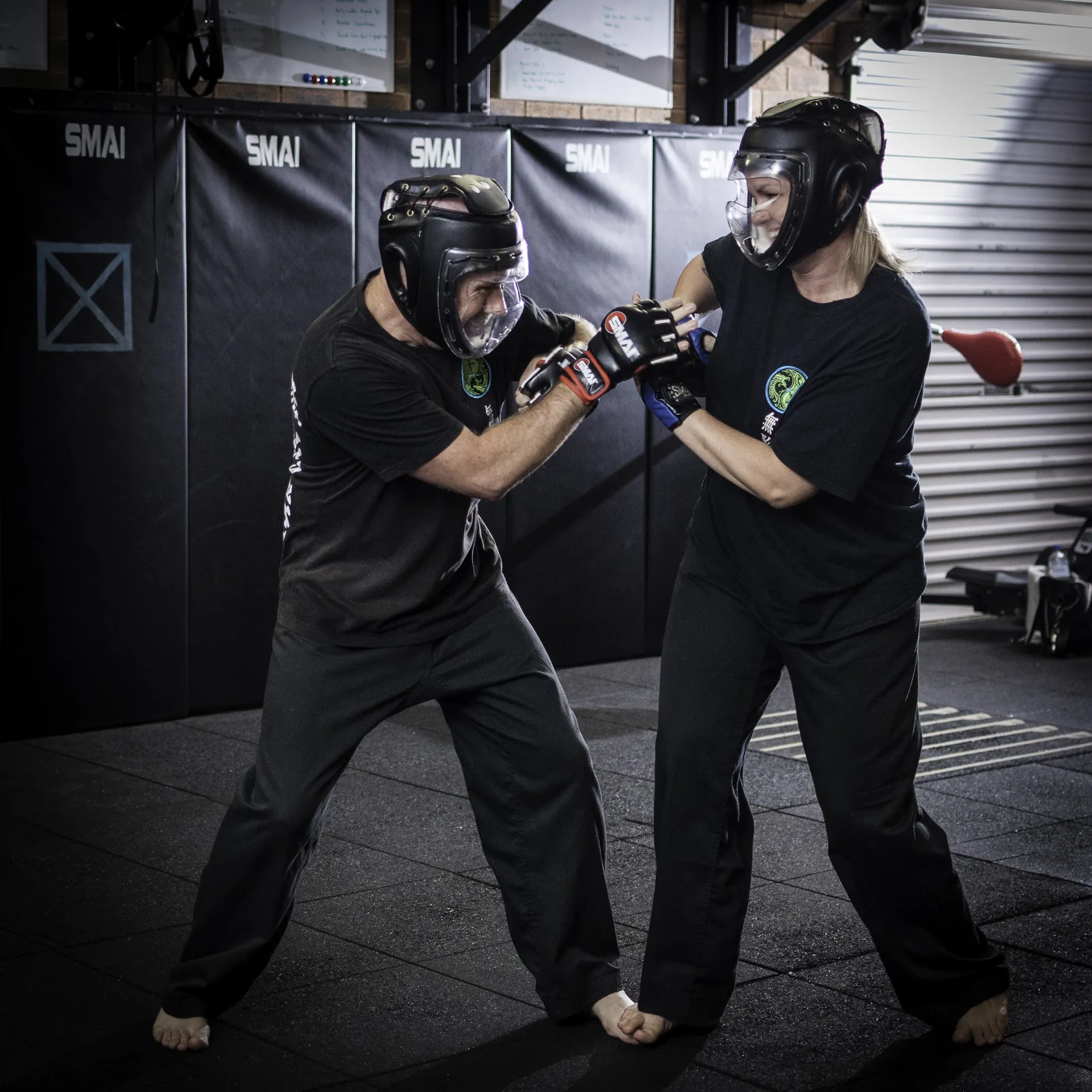 Two students in headgear and gloves spar safely in the school.
