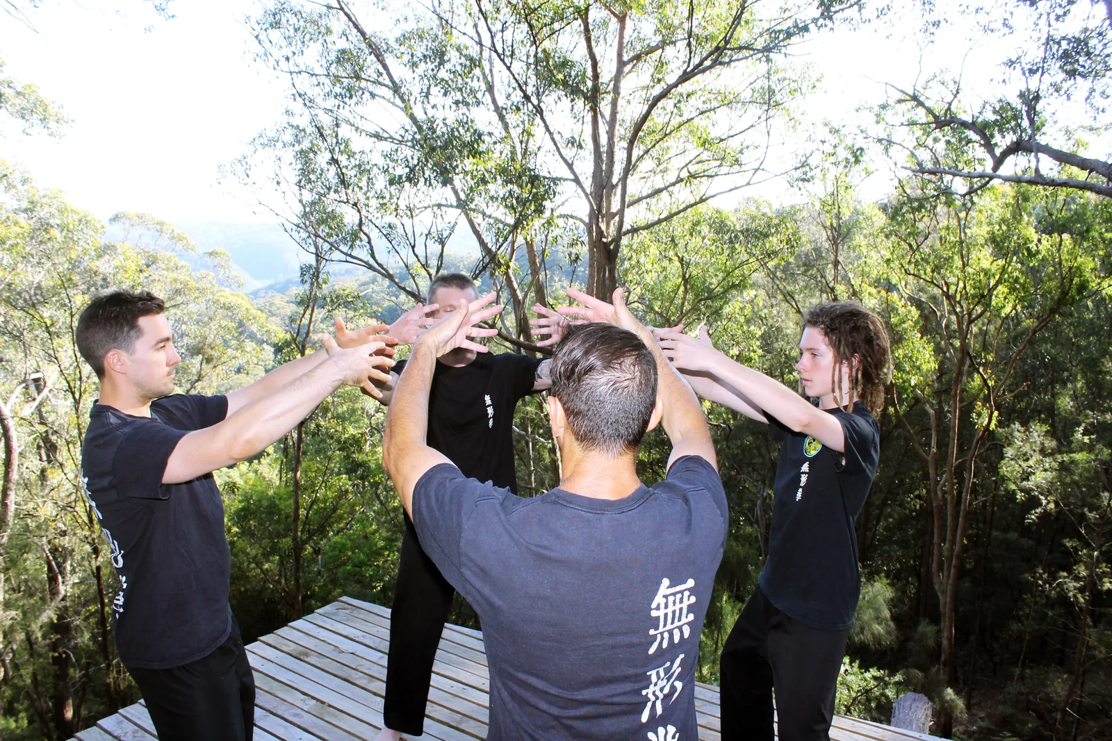 A group practises Qigong together at a retreat in the bush.