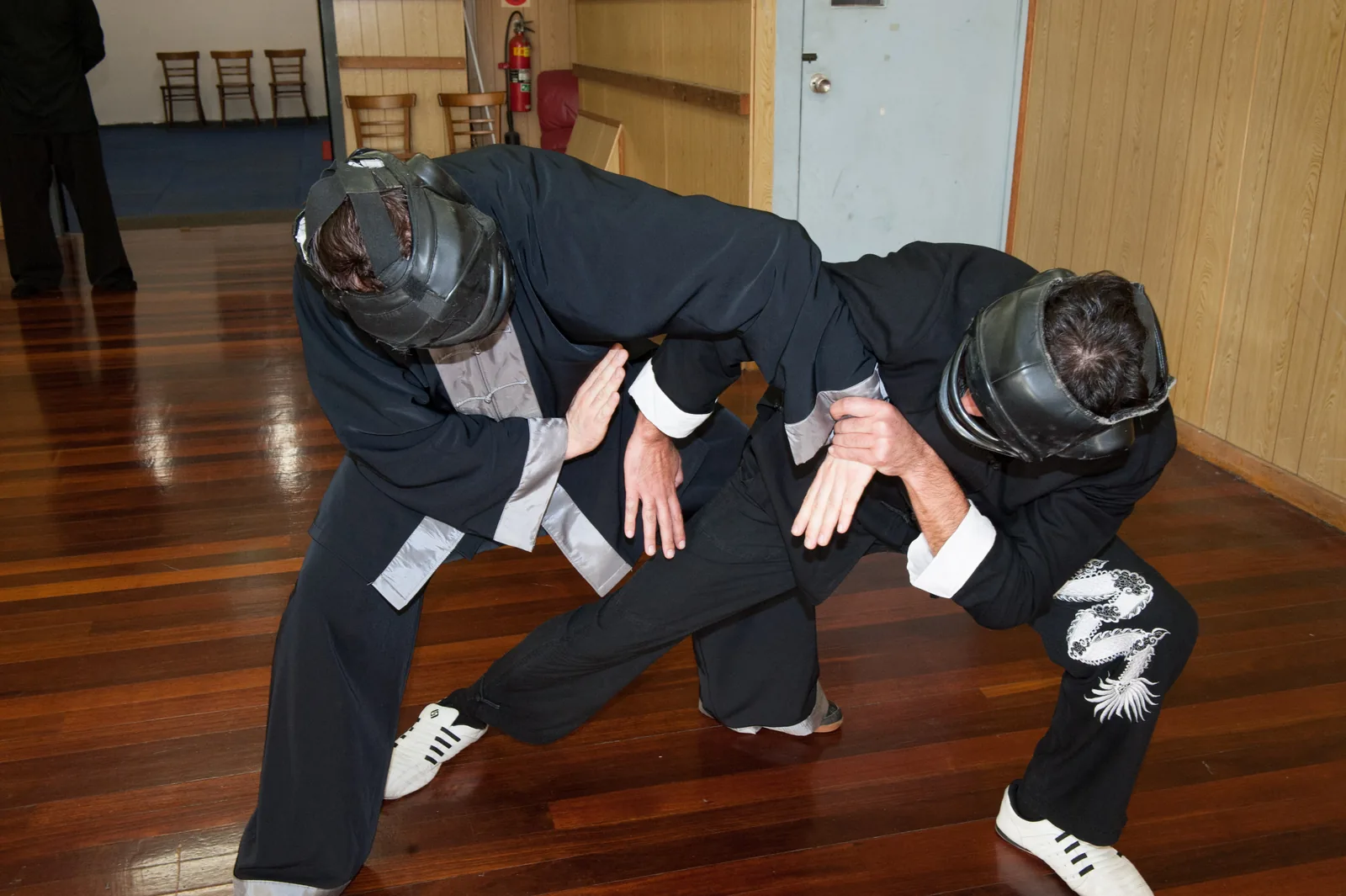 Two students in headgear practise close-range fighting.