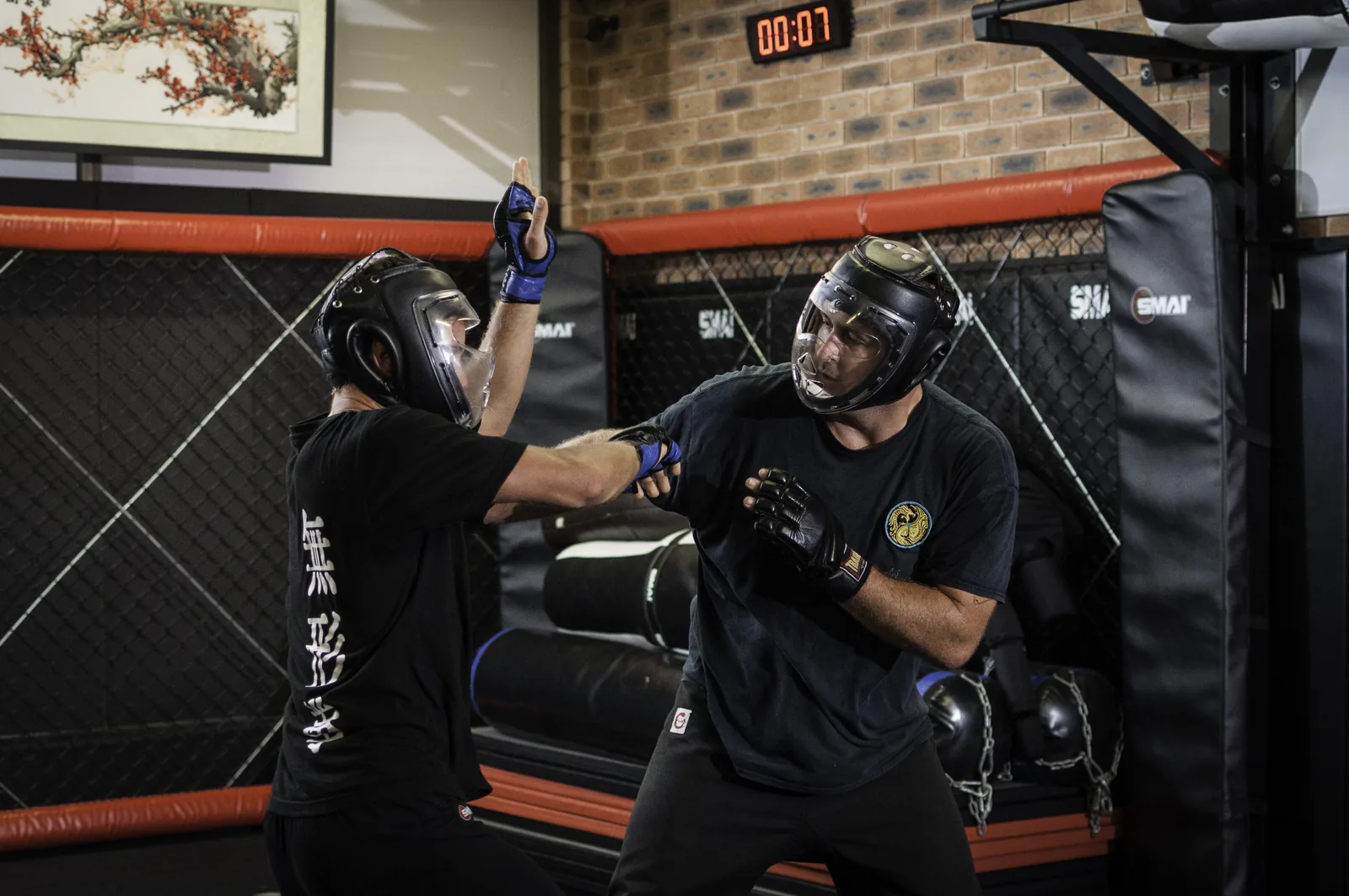 Two kung fu students in headgear spar in the Wu Xing Dao school.