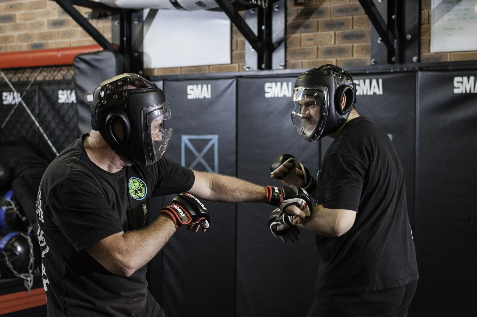 Students spar in full headgear and gloves under supervision.