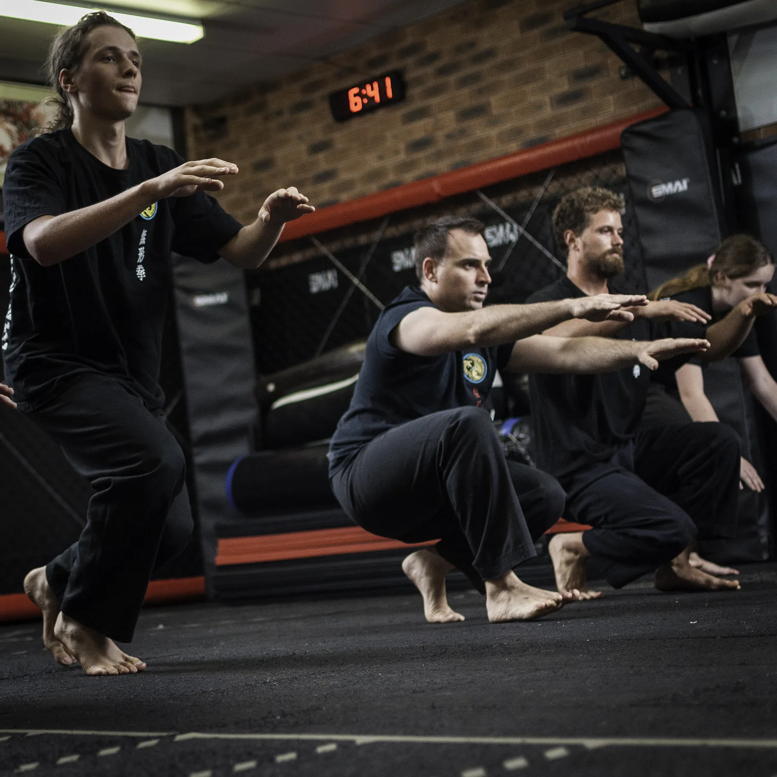 Students combine Qigong breathing with low kung fu stances in class.