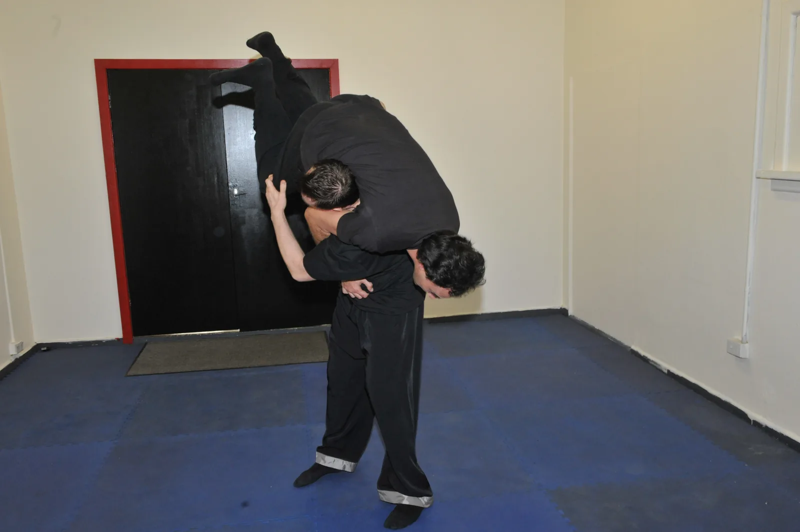 A wrestling throw: one student lifts a training partner off the mat.