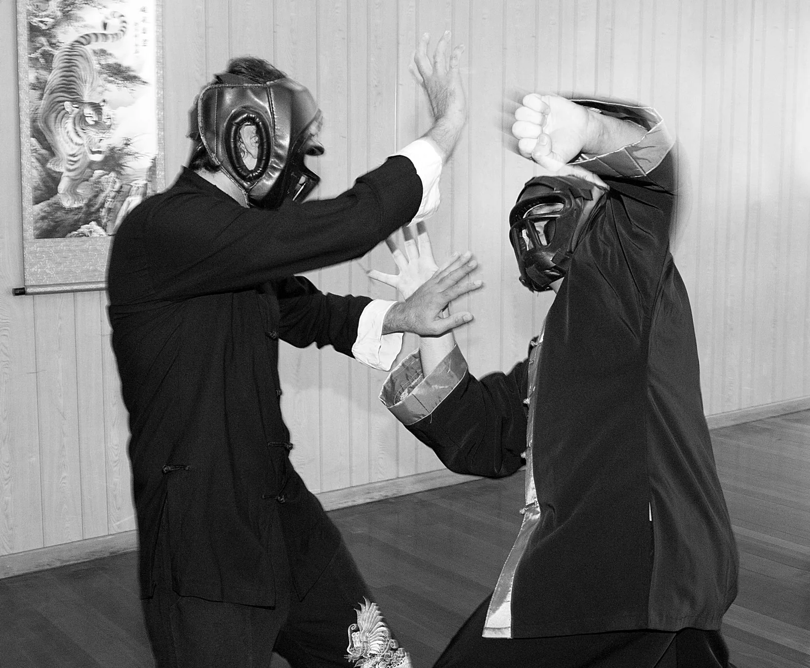 Sparring in protective headgear, in black and white.