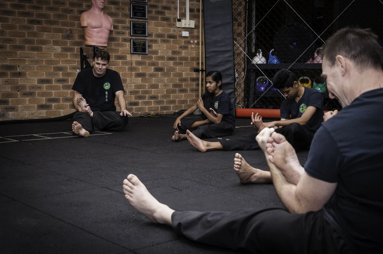 Students stretch on the mats to warm up safely.