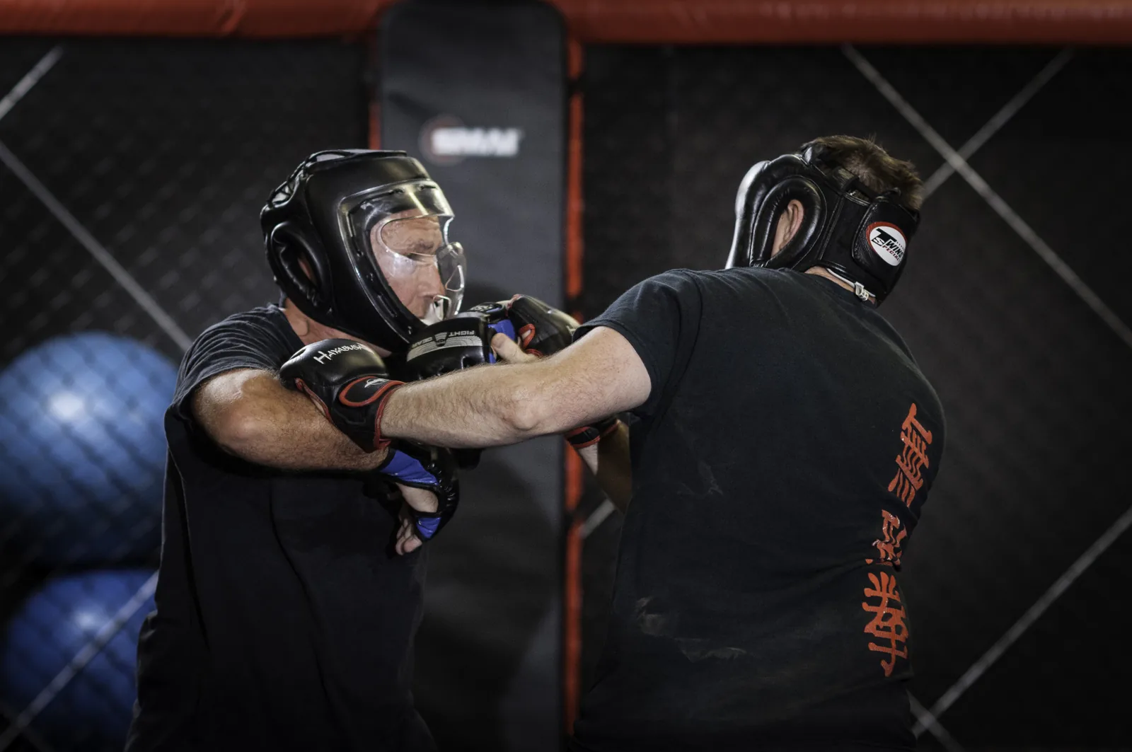 A student wearing protective headgear and gloves in sparring.