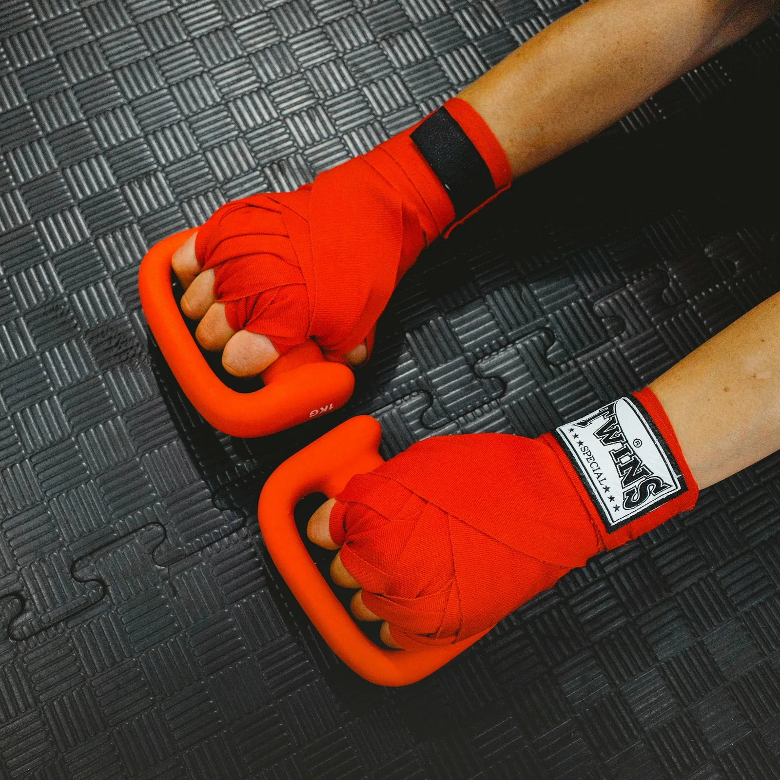 Hands wrapped in red boxing hand wraps.