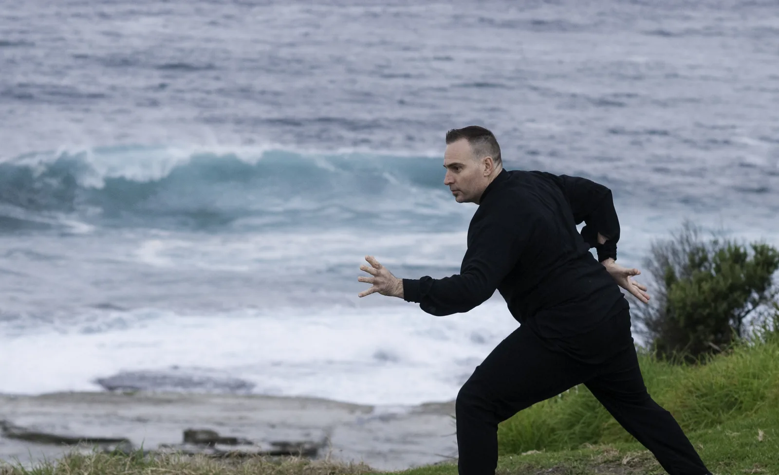 A Qigong stance beside crashing waves at Terrigal.