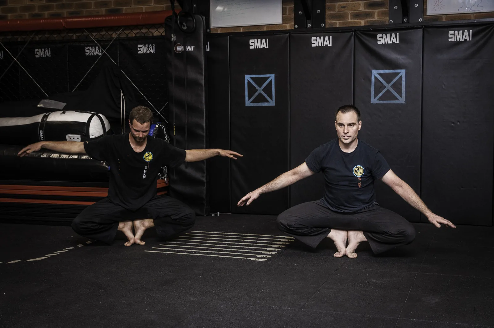 An instructor and a student work through seated mobility exercises.