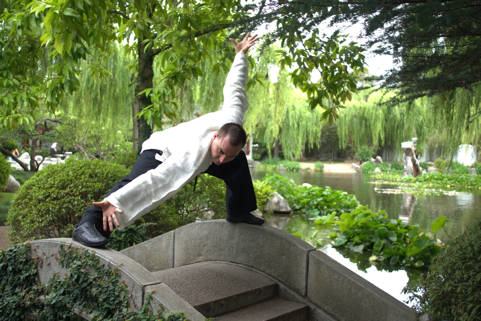 Balancing on one leg on a Chinese garden bridge during Baguazhang practice.
