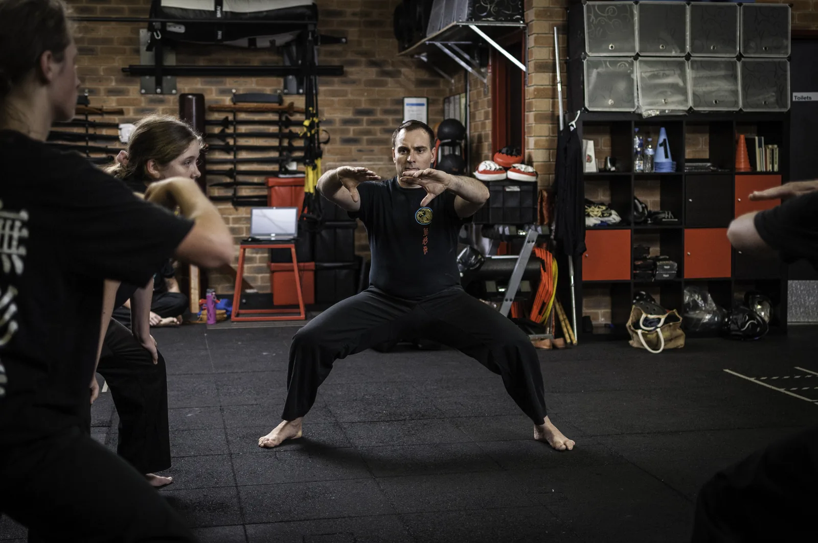 Students hold a deep, powerful horse stance in class.