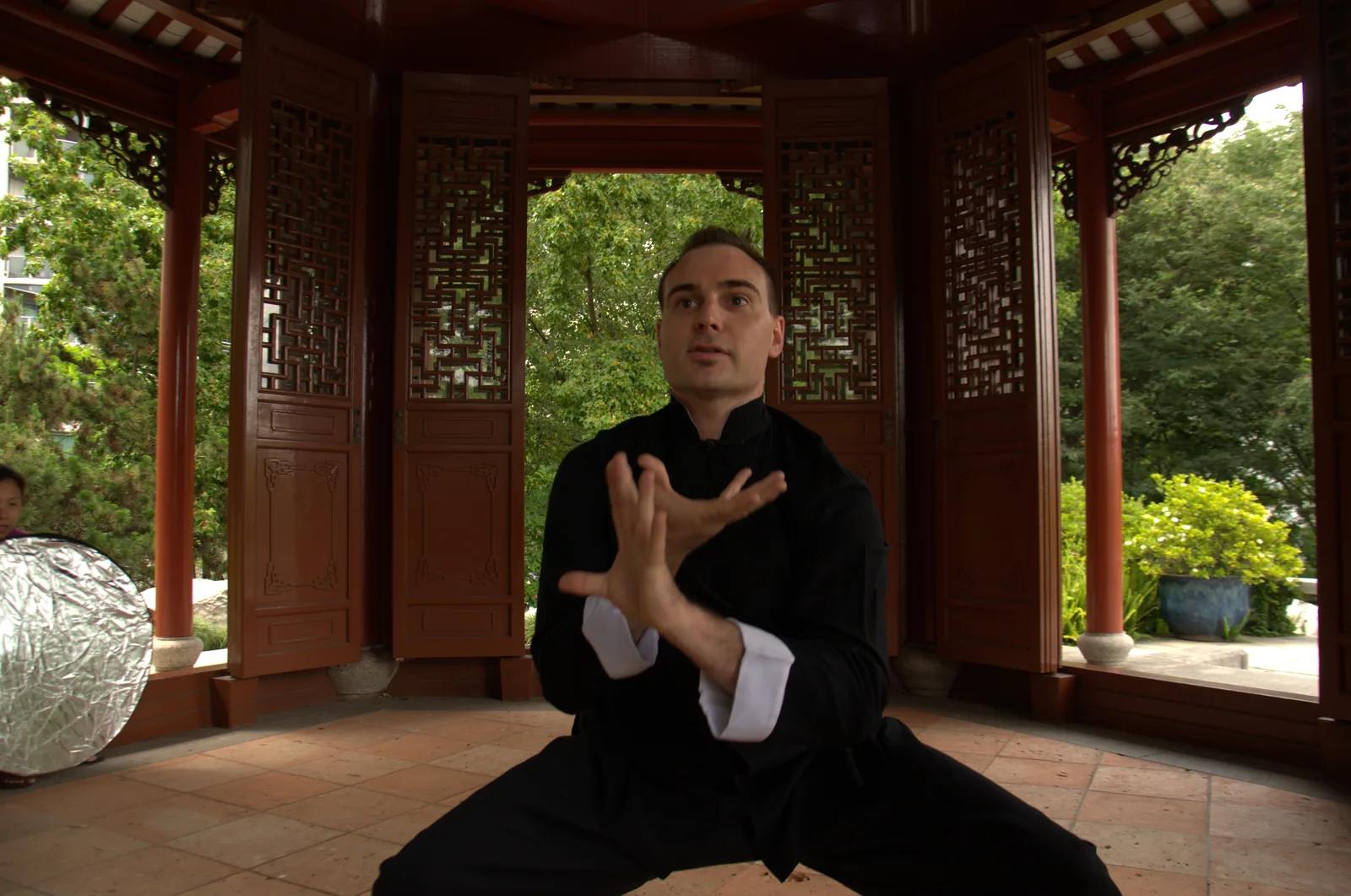 Traditional Chinese martial arts practice inside a garden pavilion.