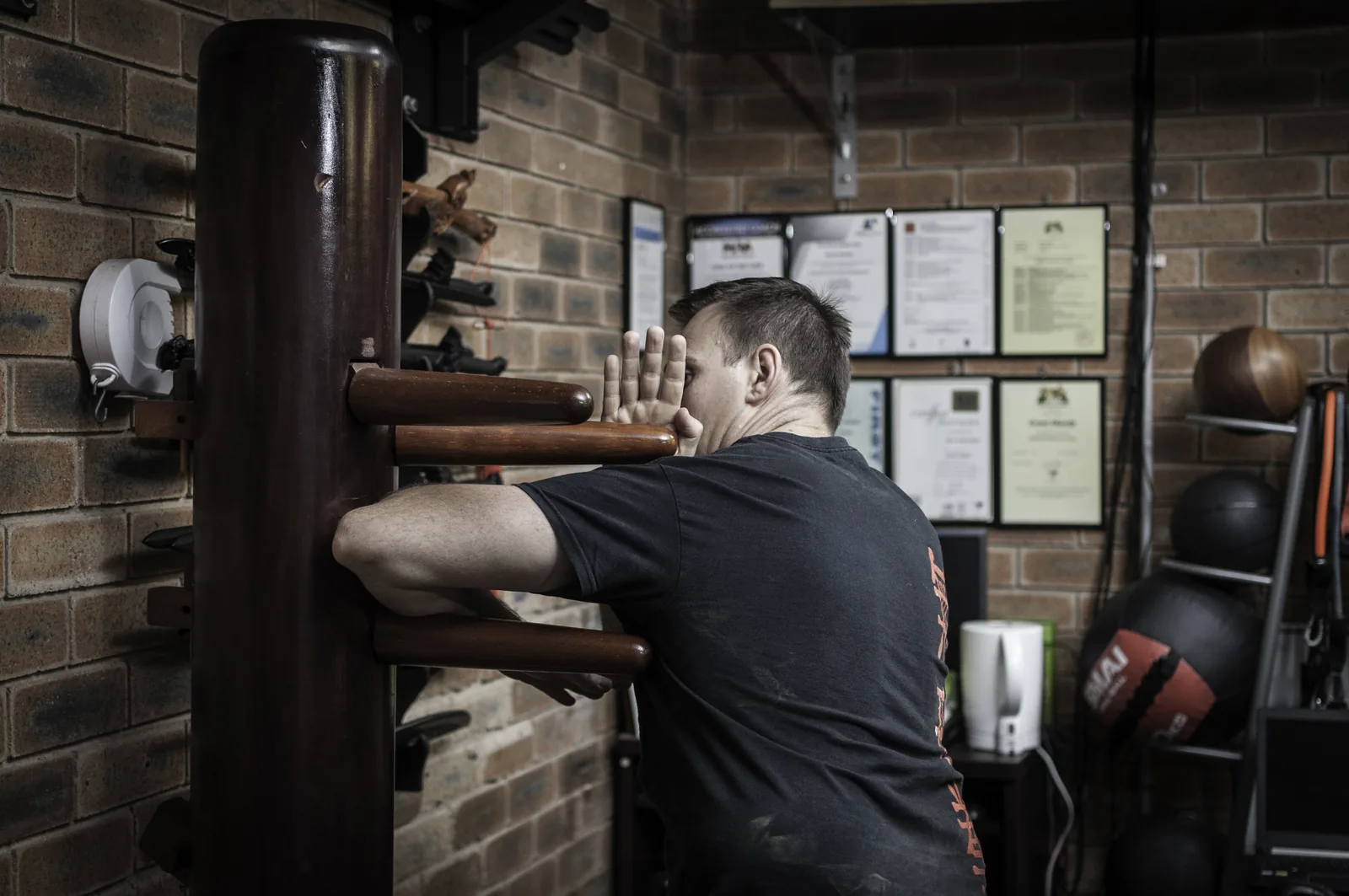 A student trains on the Wing Chun wooden dummy (mook yan jong).