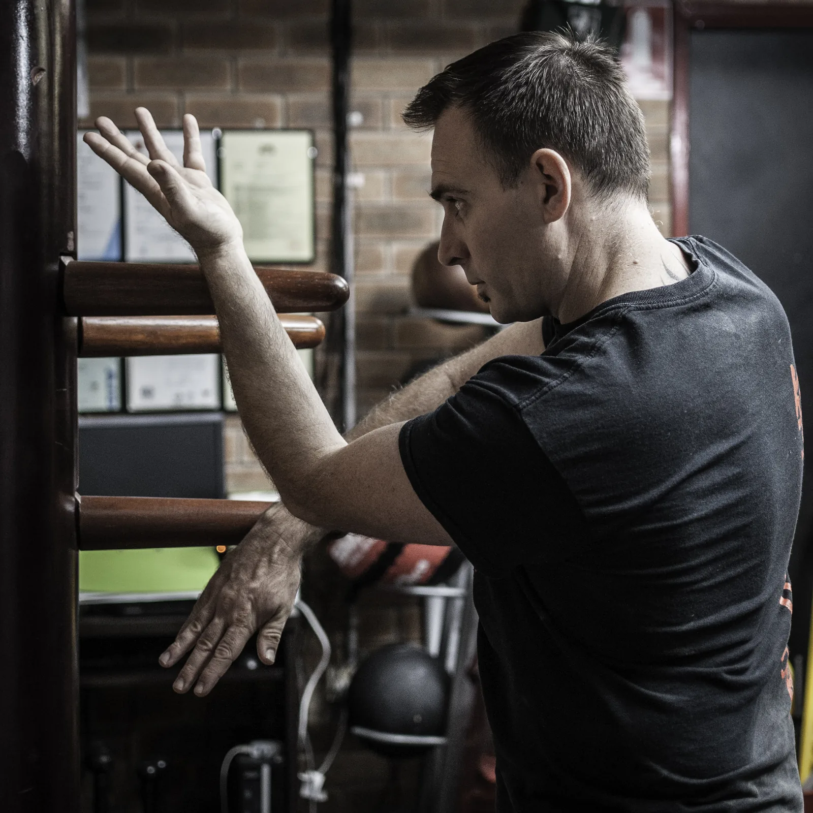 Close-up of wooden dummy training: hands and forearms working the arms of the dummy.